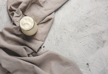 Jar of tasty sour cream on light table
