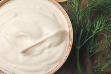 Bowl of tasty sour cream on table, closeup