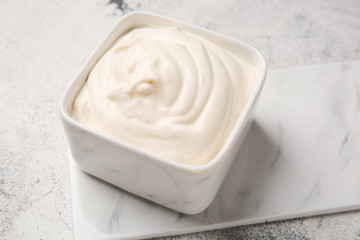 Bowl of tasty sour cream on table