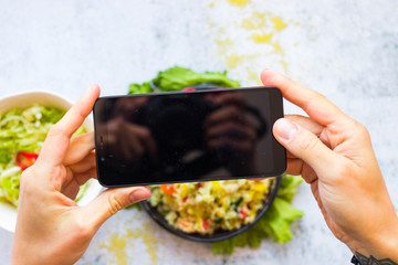 Phone food photography. Smartphone food photo of couscous vegetables salad  in woman hands. Vegan, vegetarian healthy lunch, dinner or breakfast.