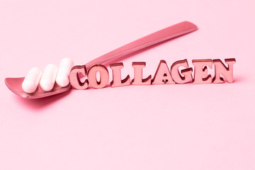 The inscription collagen and white capsules in a spoon on pink background.