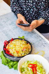 Phone food photography. Smartphone food photo of couscous vegetables salad  in woman hands. Vegan, vegetarian healthy lunch, dinner or breakfast.