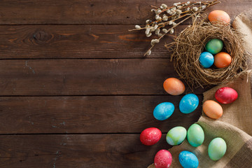 Still life many colorful easter eggs on a wooden background. Rustic. Decoration from natural fabrics and herbs. Easter celebration concept. Flat lay
