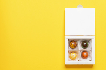 Box with delicious candies on color background