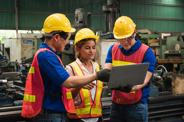 The industrial worker team is working on various projects in a large industrial factory with many...