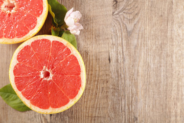 red grapefruit and leaf on wood background