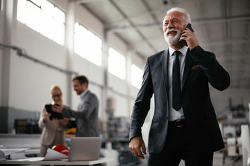 Handsome businessman using phone. Businessman talking to smart phone.	