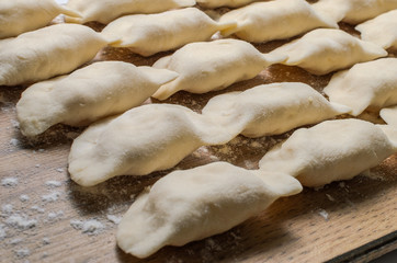 Raw dumplings made of dough in handmade flour