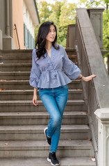 Fototapeta premium Young Asian Girl walking down stairs in Europe city. Europe city woman traveller lifestyle. Travel Europe summer holiday girl enjoying her holiday. Vacation and Holidays in Zurich and Europe concept.