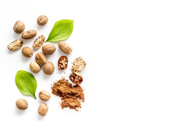 Nutmeg - whole nuts and powder - on white background top-down copy space