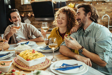 Cheerful couple laughing and having fun at dining table.