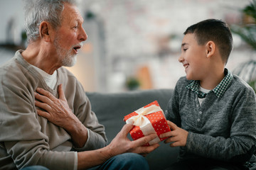 Grandfather giving gift to grandson.	