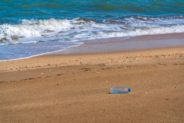 Fototapeta na wymiar Plastic water bottle on the beach