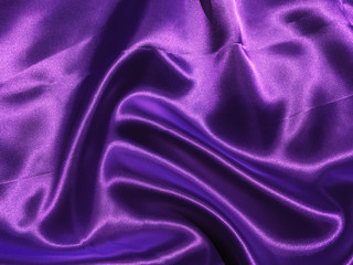 Smooth purple fabric or satin texture background with copy space for design