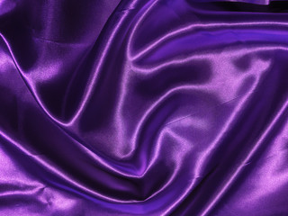 Smooth purple fabric or satin texture background with copy space for design