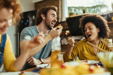 Below view of friends enjoying in lunch at dining table.