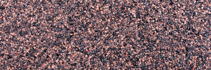 Closeup red and black bitumen shingles. Rough background made of roofing material