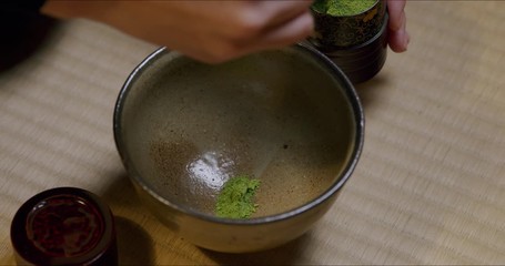 Japanese tea ceremony. Close-up of carefully putting matcha (Japanese green tea) in a bowl.