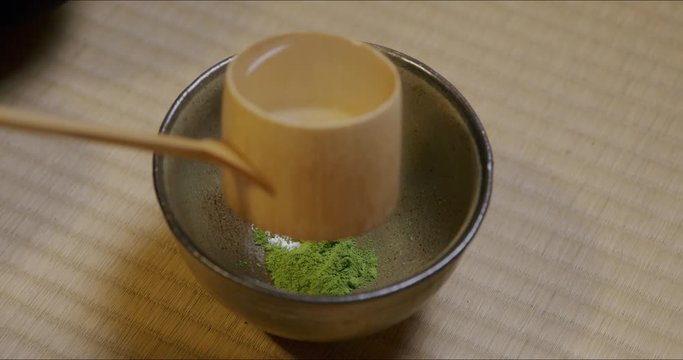 Japanese tea ceremony. Close-up of pouring water into bowl and whisking matcha (Japanese green tea).