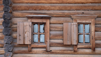 Obraz na płótnie Canvas Traditional old houses made of wooden planks. Two ancient windows in the wooden walls.