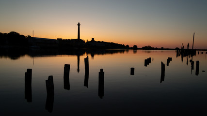 Fototapeta premium Sunset at sea port. beautiful shadows of old pier wooden pillars