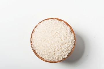 Fototapeta na wymiar Rice in a wooden bowl isolated under a straw mat on a white background. Tile (top)