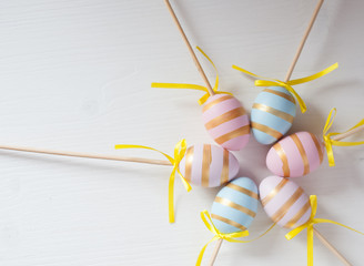 Easter eggs blue and pink on a stick on a wooden background