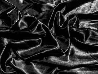 Black satin texture background with liquid wave or wavy folds. Wallpaper design