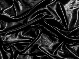 Black satin texture background with liquid wave or wavy folds. Wallpaper design