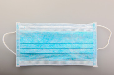 Fototapeta premium Typical three-layer protective surgical mask. The edge with double stitches is designed to cover the nose, and a metal wire is concealed within so the mask can be fitted securely to the nasal bridge.