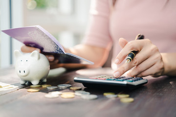 Business woman hands holding saving account passbook with calculator, account and saving concept.