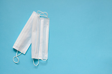 Two  white face masks on a blue background. Concept of coronavirus quarantine