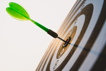 Green darts arrows in the target center on the sky background. Business target or goal success and...
