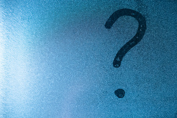 Question mark written by a finger on a misted glass. copy space