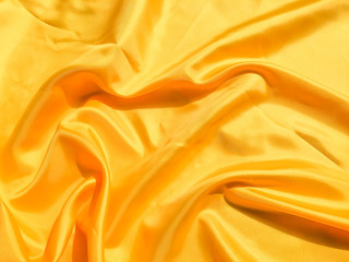 Beautiful yellow silk or satin texture background with copy space for design and artwork