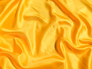 Fototapeta premium Beautiful yellow silk or satin texture background with copy space for design and artwork