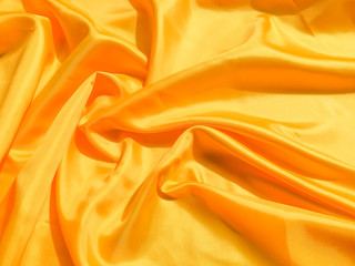 Obraz premium Bright yellow silk with waves moving for background. Abstract design with copy space