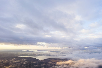 Fototapeta premium Aerial view White clouds in blue sky. View from drone. Aerial top view cloudscape. Texture of clouds. View from above. Sunrise or sunset over clouds. Panorama clouds