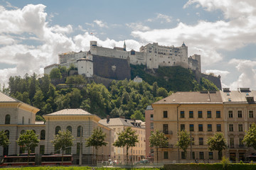 View on majestic Hohensalzburg fortress from Salzach riverbank on sunny day