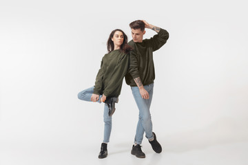 Supporting. Trendy fashionable couple isolated on white studio background. Caucasian woman and man...