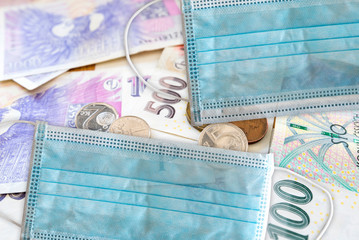 Czech money and face mask (respirator) as a symbol of problems with coronavirus and Czech health care