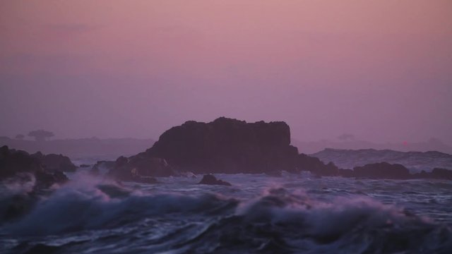 Water Smashing into big rocs at sunset. Purple colors 
California Monteray. 4K