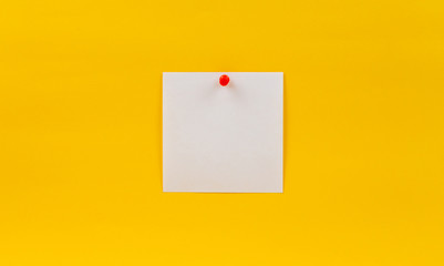 Empty blank white paper note pinned red pin on a yellow background