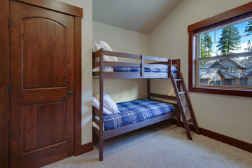 Boys or kids bedroom interior with bunk bed, blue blankets and beige new room.
