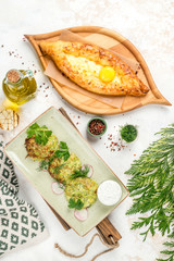 Khachapuri and potato pancakes in one photo shot from above