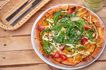 pizza with fresh vegetables on the wooden background