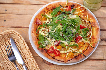 pizza with fresh vegetables on the wooden background