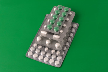 tablets, medicines in blister packs, isolated on a green background