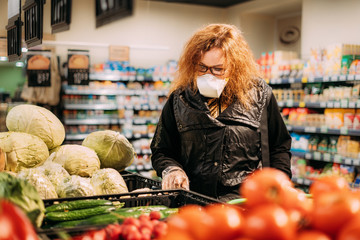 woman in medical masks in the supermarket looking for the food