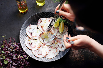 Octopus carpaccio. Seafood dish. A plate with an appetizing dish. Application suggestion. Culinary photography, food stylization.